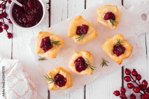 Slika na platnu Holiday puff pastry appetizers with cranberries and baked brie