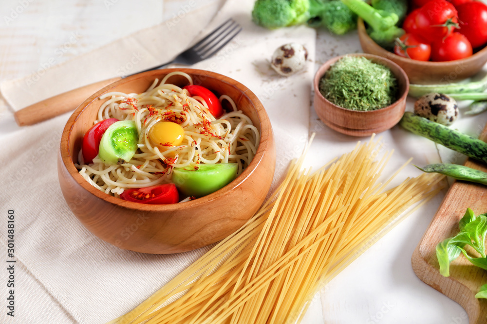 Bowl with tasty pasta, tomatoes and egg on table Bowl with tasty pasta, tomatoes and egg on table