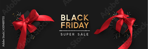 Black Friday Super Sale. Realistic black gifts boxes. 3d snowflakes with glitter gold confetti, gift box with red bow. Dark background golden text lettering. Horizontal banner, poster, header website.