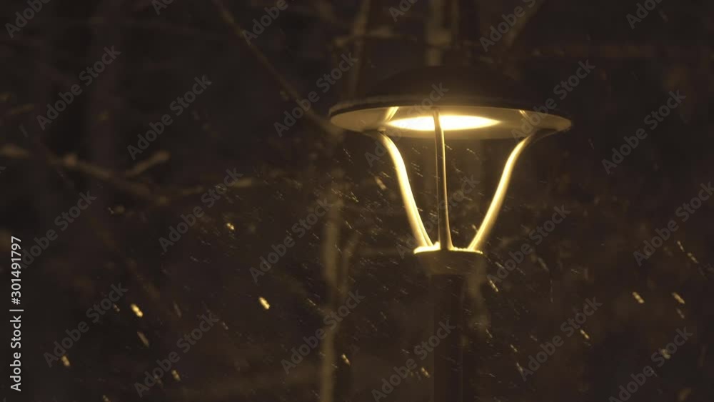 Streetlights fall asleep in heavy snow. Bright light of lanterns on the snowy streets of a winter city. Night winter landscape. Streetlights fall asleep in heavy snow. Bright light of lanterns on the snowy streets of a winter city. Night winter landscape.