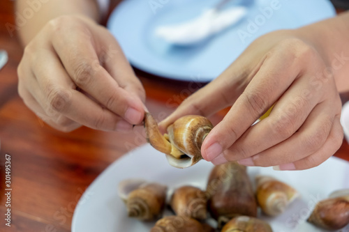 Hand of woman pulling grilled sweet burnt shells