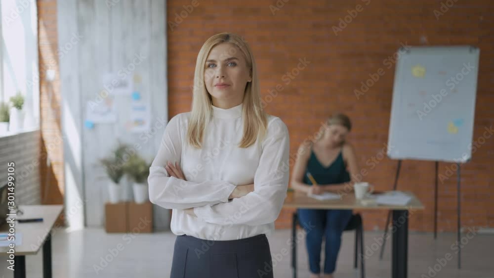 portrait of a successful girl medium shot, friendly woman smiling looking at the camera with her arms crossed. modern office 4K portrait of a successful girl medium shot, friendly woman smiling looking at the camera with her arms crossed. modern office 4K