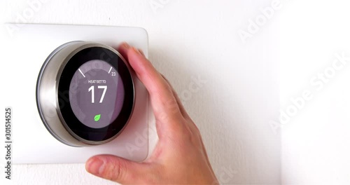 4k Smart Thermostat with a someone cooling down the temperature. Saving energy. photo