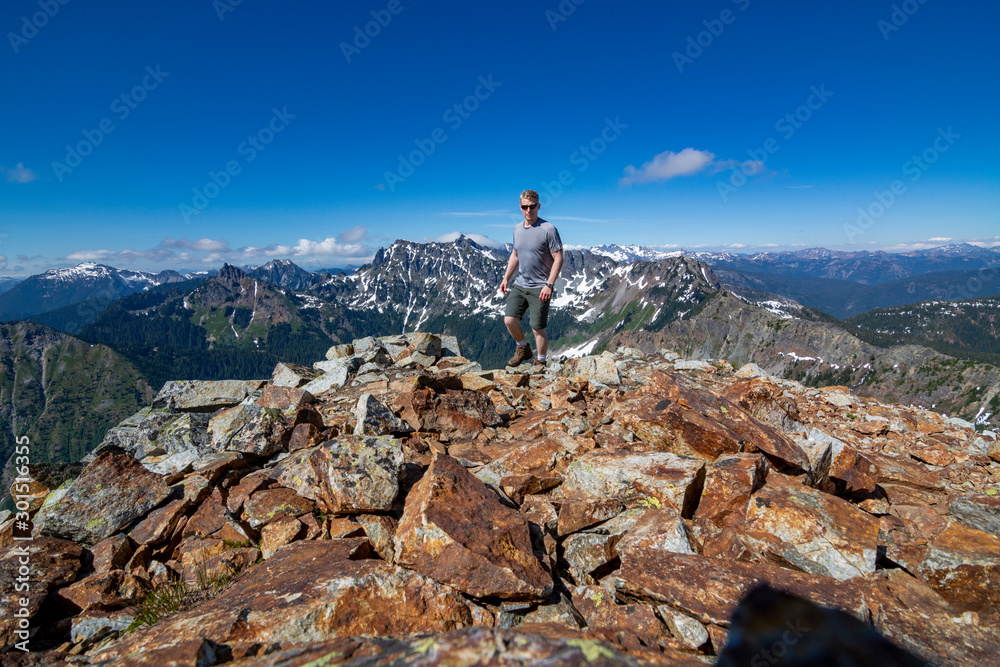 Adventurous man hiking on top of a mountain.