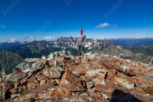 Adventurous man hiking on top of a mountain.