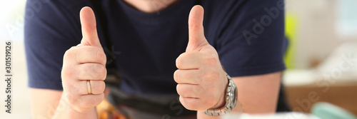 Arm of worker show confirm sign with thumb up