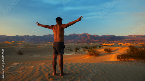 A man cheers to the sunset in the desert