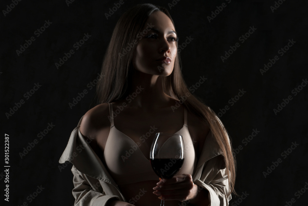 Gorgeous sexy woman with glass of red wine, silhouette style studio portrait. Dark background Gorgeous sexy woman with glass of red wine, silhouette style studio portrait. Dark background