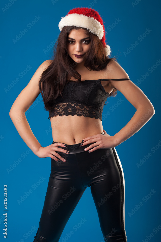 attractive brunette in black leggings and santa claus hat. studio portrait attractive brunette in black leggings and santa claus hat. studio portrait