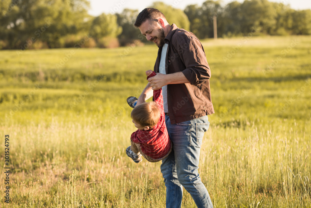 Father's day. Happy family Dad and toddler son playing and laughing on nature at sunset