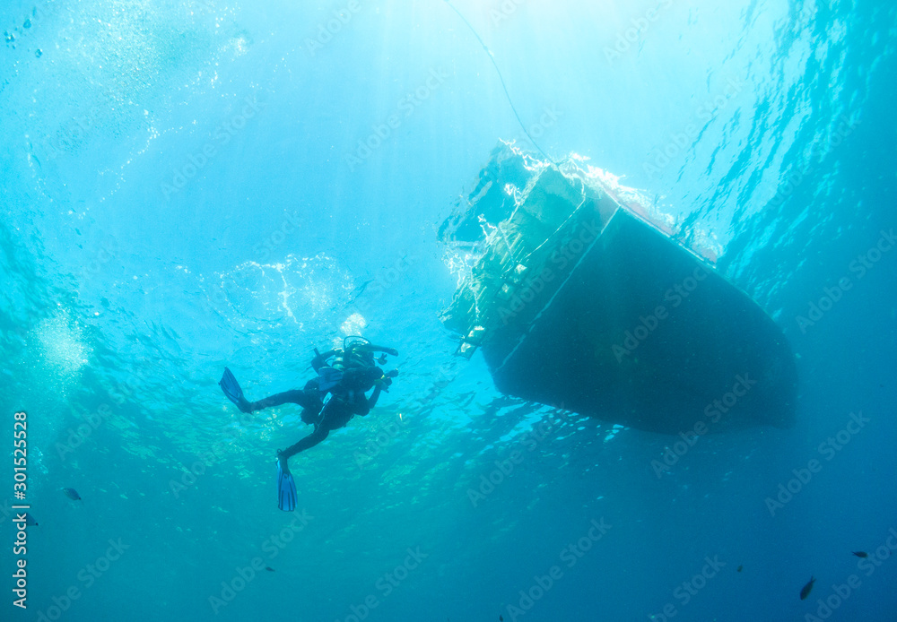 underwater landscape with diver and bottom of the boat