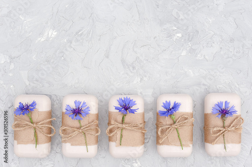 Fotografi Handmade natural soap set decorated with craft paper, scourge and blue flowers