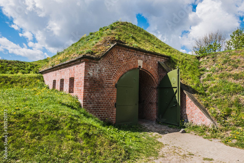 Foto Bunker covered with ground and grass, dugout made by bricks and steel hidden under hill