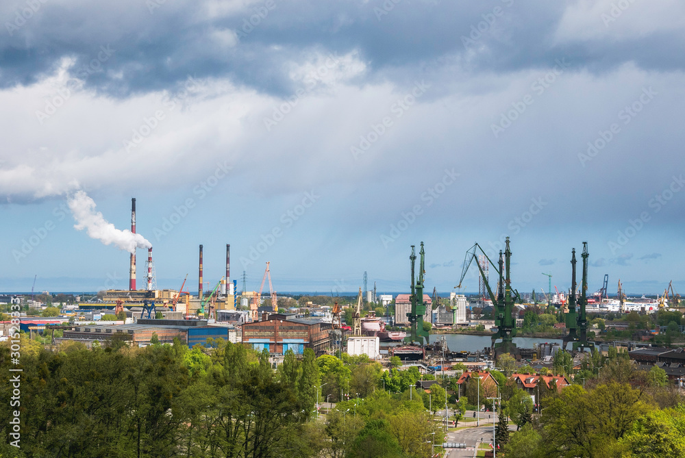 Panoramic view from Gradowa Gora on old port in Gdansk with green cranes and smoking chimneys.
