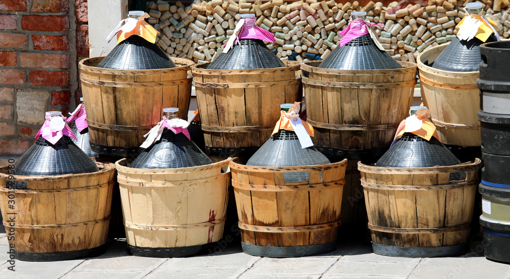 many capacious demijohns outside a wine bar many capacious demijohns outside a wine bar