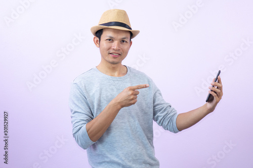 Happy  asian  man  shopping  with smart  phone  on  pink  background.