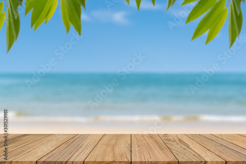 Wood table top on blur beach background. For montage product display or mock up for space
