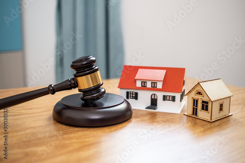 Lawn auction hammer and small house on the table, real estate mortgage auction