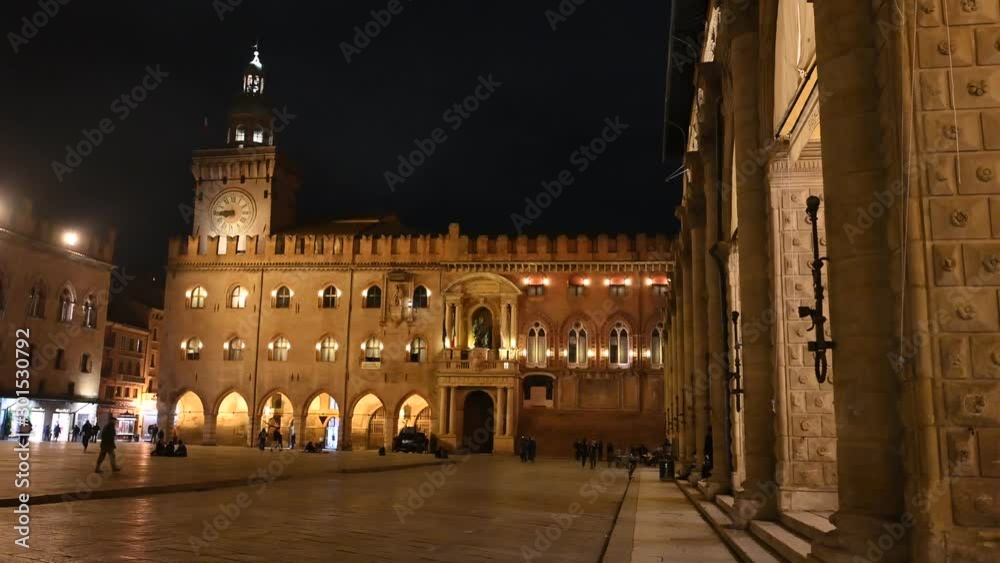 Bologna, Italy - October 2019 - Unknown people walk in the evening among the buildings and monuments of the historic city center, followed by the shadows of the night Bologna, Italy - October 2019 - Unknown people walk in the evening among the buildings and monuments of the historic city center, followed by the shadows of the night