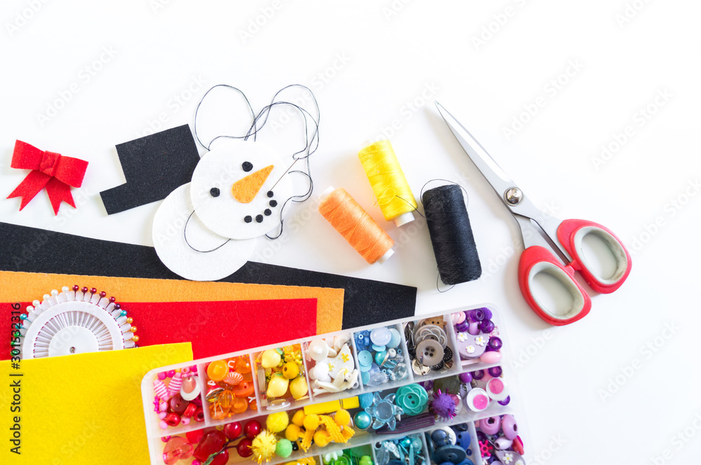 Fototapeta premium We sew a toy snowman made of felt. Christmas symbol.
