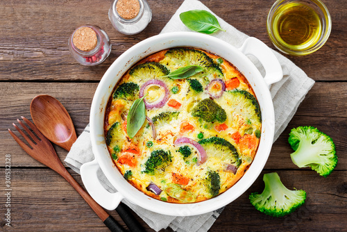 Frittata or casserole with broccoli and vegetables in baking dish. Vegetarian recipe.