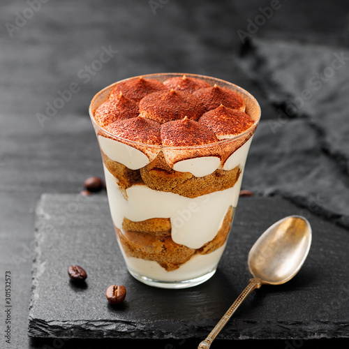 Classic tiramisu in a glass on a black background. photo