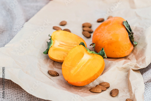 Picnic on the beach with persimmons, almond and bottle of rose wine on beige blanket. photo