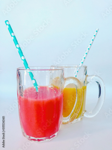 Two glasses of fresh juice. Two colorful fruit shakes. Summer and tropical smoothies. Cold blended drinks, fruit smoothie.