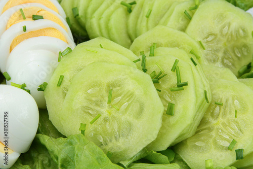 sliced cucumber and egg cooked hard on a plate photo