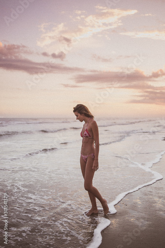 woman walking on the beach going to the sea