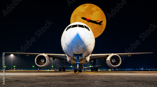 aircraft parking at gate in night with fullmoon and aircraft take off