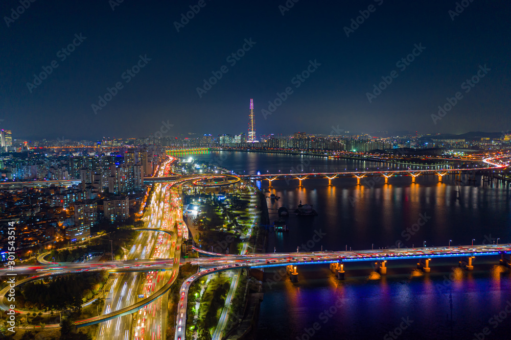 Aerial view of Seoul downtown city skyline with light trails on expressway and bridge cross over Han river at night in Seoul city, South Korea.