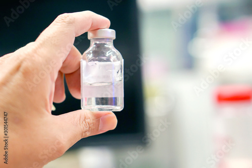 Closeup and crop Injection and medicine bottle in human hands on blurred background..