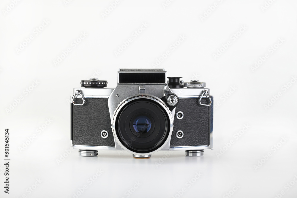 The old German 35 mm SLR film camera with lens 50 mm lens on a white background.
