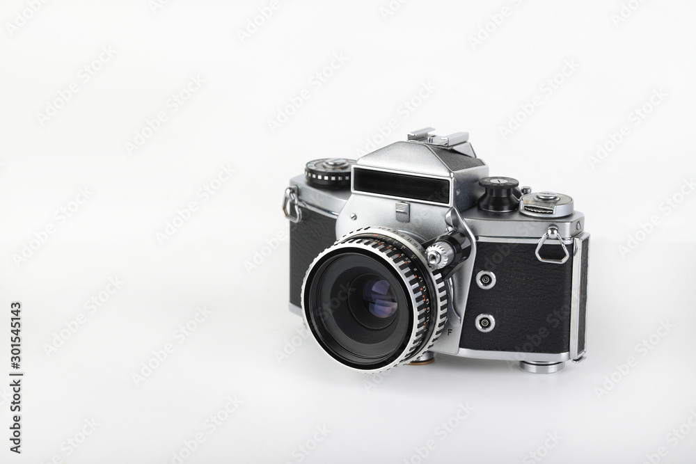 The old German 35 mm SLR film camera with lens 50 mm lens on a white background.