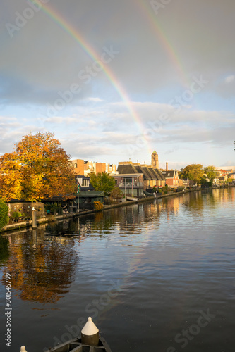 Autumn shower with double rainbow over a river in Holland