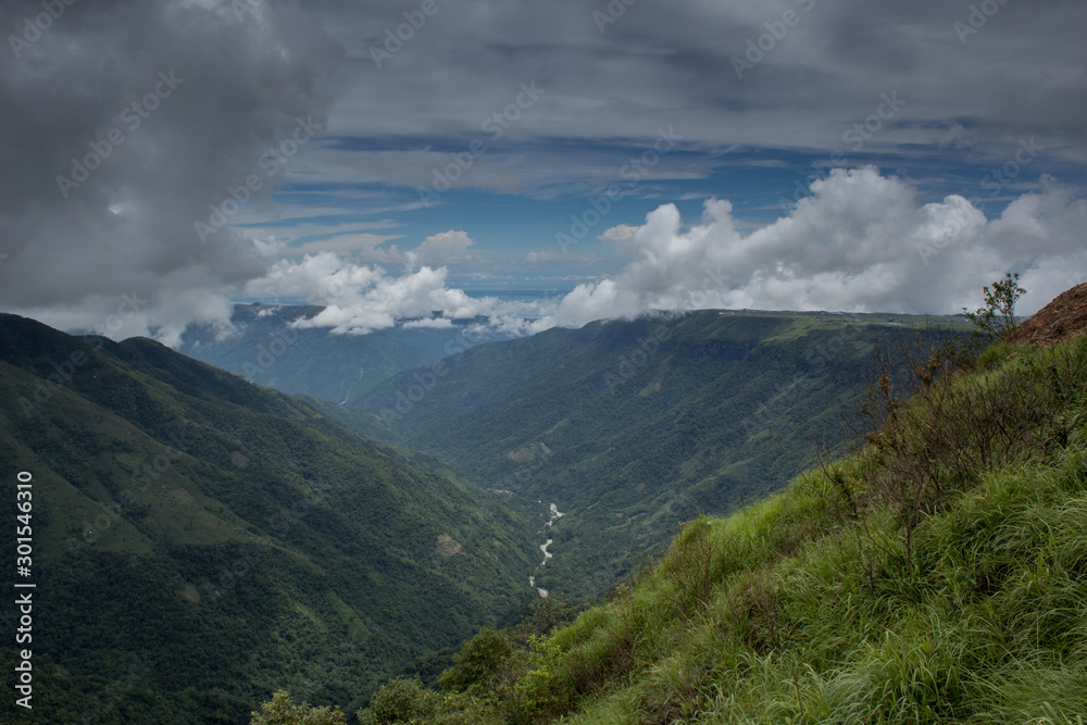 River course between hills covered with dense clouds in Meghalaya, India
