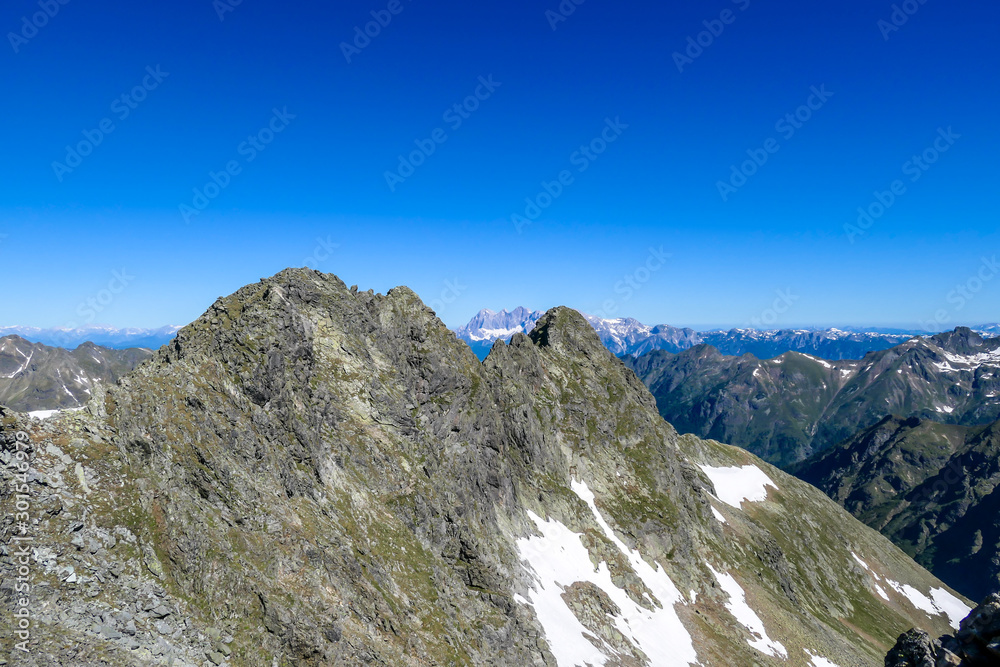 Massive, sharp stony mountain range of Schladming Alps, Austria. The mountain has a pyramid shape, it is partially overgrown with green bushes. Dangerous mountain climbing.Clear and beautiful day.