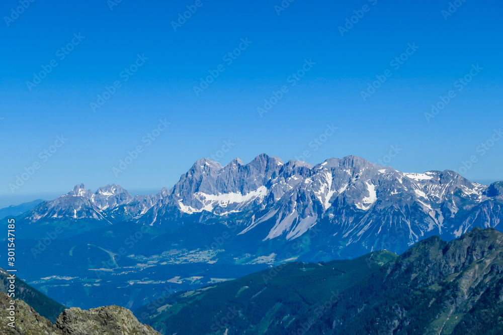 Massive mountain range of Schladming Alps, Austria. The slopes are steep, partially covered with snow. Nature waking up. Dangerous mountain climbing.Clear and beautiful day. Endless mountain ranges Massive mountain range of Schladming Alps, Austria. The slopes are steep, partially covered with snow. Nature waking up. Dangerous mountain climbing.Clear and beautiful day. Endless mountain ranges