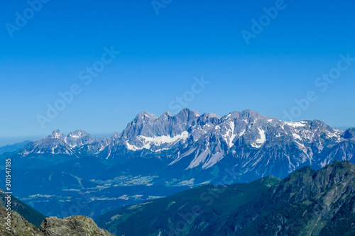 Massive mountain range of Schladming Alps, Austria. The slopes are steep, partially covered with snow. Nature waking up. Dangerous mountain climbing.Clear and beautiful day. Endless mountain ranges