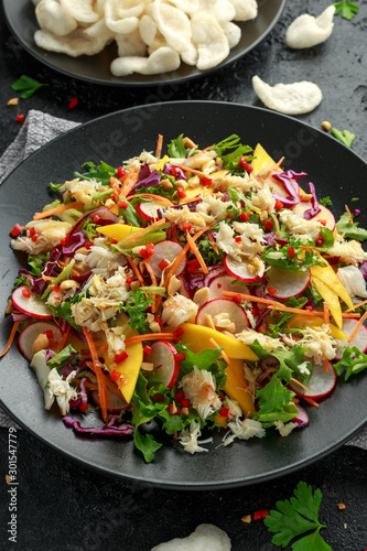 Crab salad with vegetables, radish, carrots, mango, pine nuts and prawn crackers