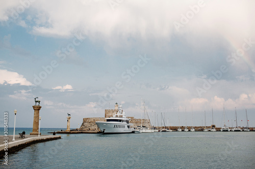 Entrance into Mandraki harbor in City of Rhodes, Greece. Panorama