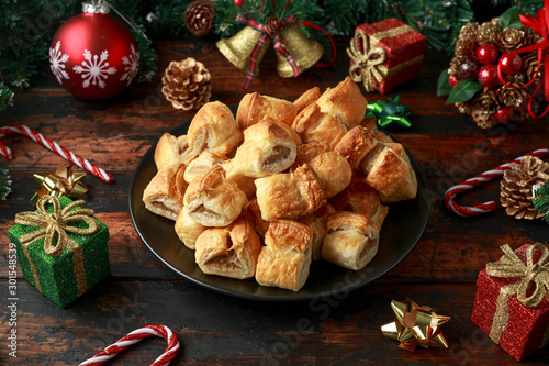British Christmas Sausage Rolls with decoration, gifts, green tree branch on wooden rustic table