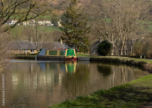 A canal boat waits by the towpath on a bend on the Leeds and Liverpool Canal nearly Keighley in Yorkshire