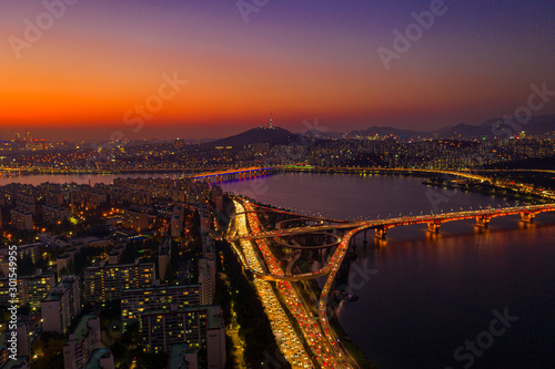 Aerial view of Seoul downtown city skyline with light trails on expressway and bridge cross over Han river at twilight sunset in Seoul city, South Korea. Aerial view of N Seoul Tower at Namsan Park
