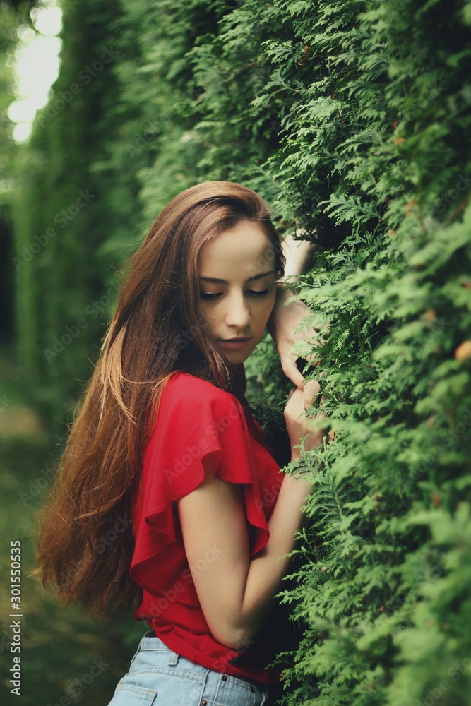Young pretty girl's portrait on parkland background
