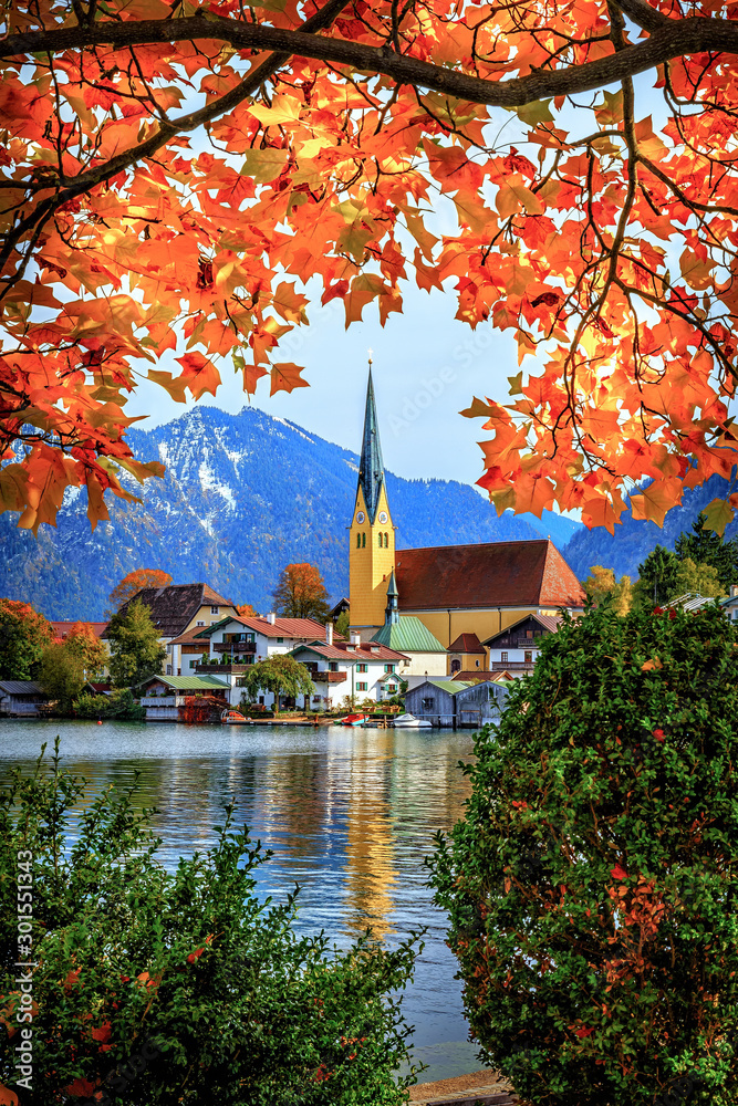 Die Kirsche St. Laurentius in Rottach-Egern eingerahmt von farbenfrohem Herbstlaub