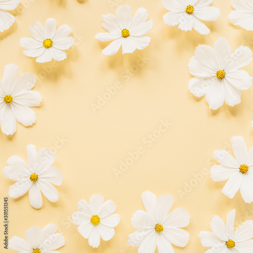 Minimal styled concept. Wreath made of white daisy chamomile flowers on pale yellow background. Creative lifestyle, summer, spring concept. Copy space, flat lay, top view. © Floral Deco