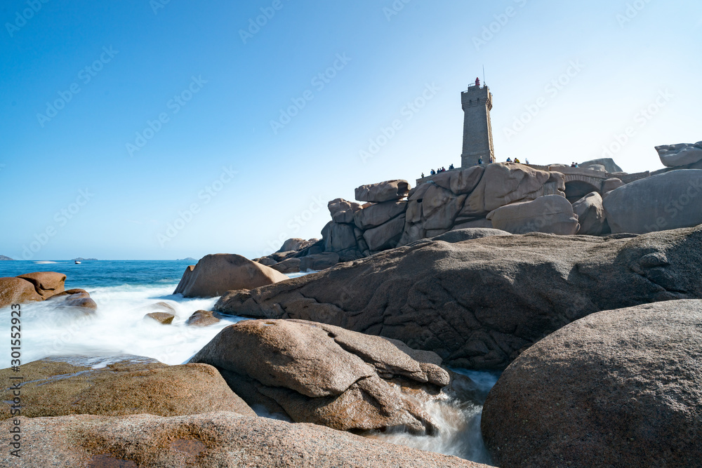 tourists visit the Men Ruz lighthouse on a beautiful day during summer vacation in Brittany