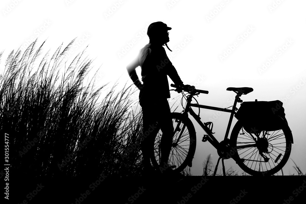 Obraz premium Black on a white background Touring cyclist Vintage bicycles are parked in the midst of grasslands and sunsets in the evening.